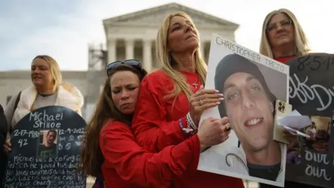 EPA people holding signs and photos for family members who died